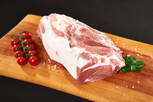 Schweinefleisch Freyberger mit Tomatendeko auf Holzbrett